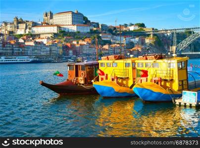 Funny touristic boats on Douro river at sunset. Porto Old Town on a background. Portugal