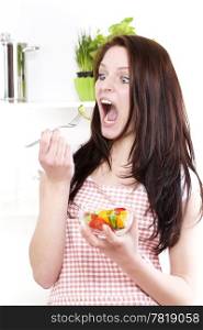 funny woman eating salad. funny woman with wide open mouth and eyes eating salad