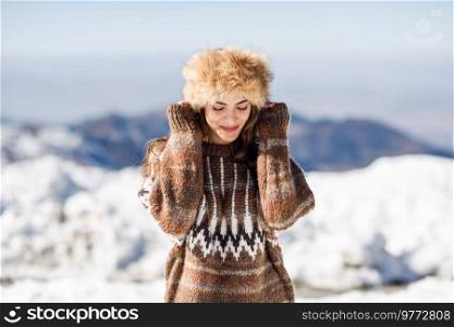 Funny woman enjoying the snowy mountains in winter, in Sierra Nevada, Granada, Spain. Female wearing winter clothes.. Young woman enjoying the snowy mountains in winter