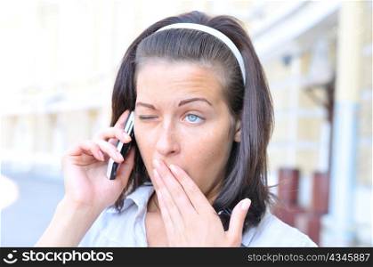 funny woman is yawning when talking phone
