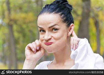 Funny woman with black hair in autumn park