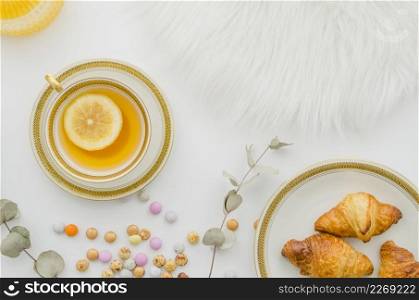 fur baked croissant candies ginger lemon tea cup white background