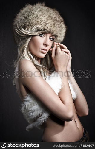 Fur Fashion. Beautiful young woman wearing a furry hat.