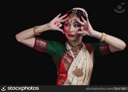 Furious Bharatanatyam dancer performing against black background