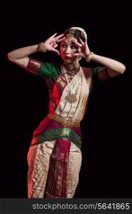 Furious Bharatanatyam dancer performing over black background