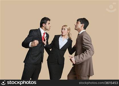 Furious businessmen in conflict with woman trying to resolve over colored background
