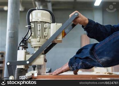 Furniture production concept  man working at machine and making furniture part. Furniture production concept
