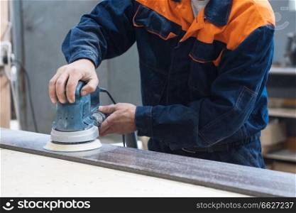 Furniture production or craft concept  worker polishing the stone surface of furniture part with polish machine. Furniture production concept
