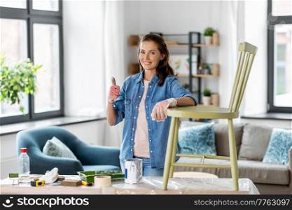 furniture restoration, diy and home improvement concept - happy smiling woman renovating old chair and showing thumbs up gesture. woman renovating old chair and showing thumbs up