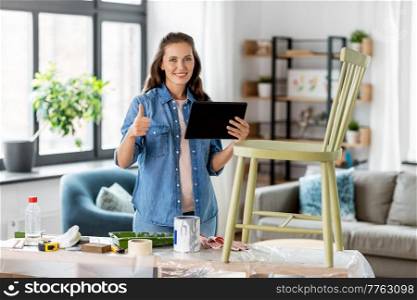 furniture restoration, diy and home improvement concept - happy woman with tablet pc computer showing thumbs up and preparing old wooden chair for renovation. woman with tablet pc and old chair shows thumbs up