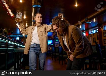 Fury woman with beer glass attacks man. Conflict at sport bar. Expressive people, angry football fans. Fury woman with beer glass attacks man, conflict at sport bar