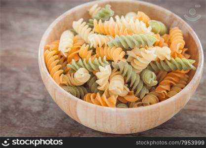 Fusili pasta in wooden plate, stock photo