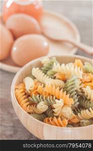 Fusili pasta in wooden plate with eggs, stock photo