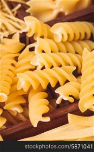 Fusilli pasta in the wooden box on the table. Fusilli pasta
