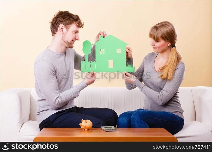 Future family real estate housing finances concept. Young couple planning future. Man with woman sitting with house model surrounded by papers.. Young couple planning future.
