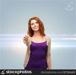 future, gesture and people concept - smiling teenage girl in casual clothes showing thumbs up over gray background with laser light