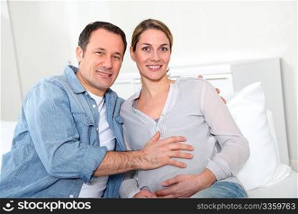 Future parents sitting in sofa at home