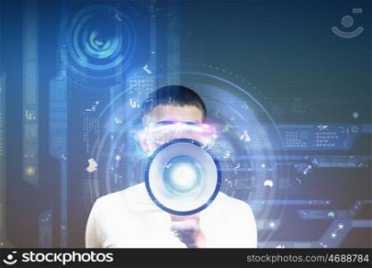 Future technologies. Young man in white screaming in megaphone against media background