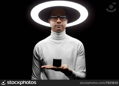 future technology and virtual reality concept - indian man in glasses with smart speaker under white illumination on black background. man in glasses with smart speaker under lamp