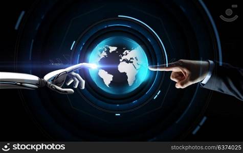 future technology, business and artificial intelligence concept - close up of businessman and robot hand touching virtual earth hologram over black background. human and robot hand with virtual earth hologram
