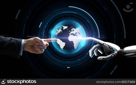 future technology, business and artificial intelligence concept - close up of businessman and robot hand touching virtual earth hologram over black background. human and robot hand with virtual earth hologram. human and robot hand with virtual earth hologram