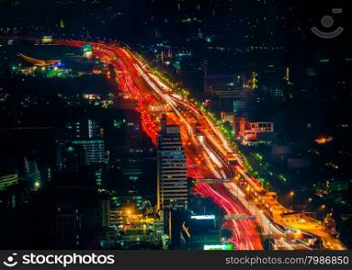 Futuristic night cityscape aerial view panorama with illuminated skyscrapers and city traffic across streets. Bangkok, Thailand