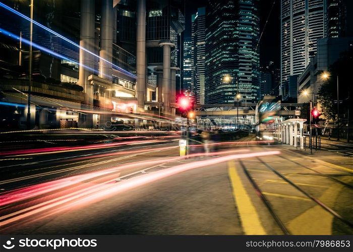 Futuristic night cityscape view with illuminated skyscrapers and city traffic across street. Hong Kong