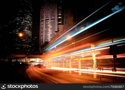 Futuristic night cityscape view with illuminated skyscrapers and city traffic across street. Hong Kong