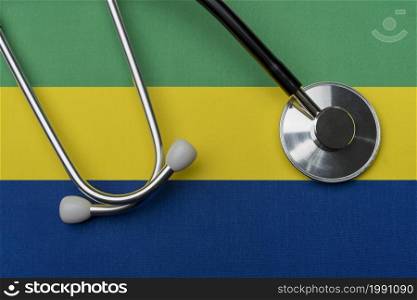 Gabon flag and stethoscope. The concept of medicine. Stethoscope on the flag as a background.. Gabon flag and stethoscope. The concept of medicine.