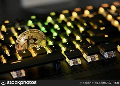Galati, Romania - April 09, 2021 Studio shot of golden Bitcoin virtual currency on a computer keybopard
