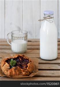 Galette with plums and bottle with milk close-up. Breakfast or lunch concept