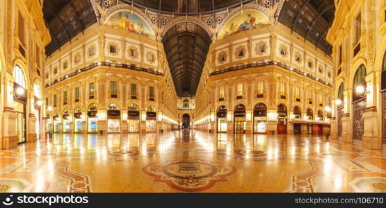 Galleria Vittorio Emanuele II in Milan, Italy. Milan, Lombardia, Italy - October 24, 2017: One of the world's oldest shopping malls Galleria Vittorio Emanuele II from inside the arcade at night in Milan. Panoramic view