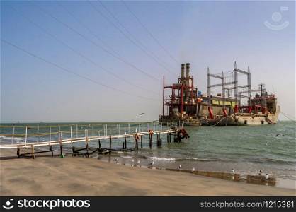 GAMBIA, BIJILO - 07 January 2020: Power plant on moored boats near Banjul beach in The Gambia