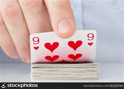 Gamble concept . Player hand revealing nine of hearts