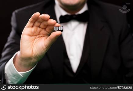 gambling, fortune, casino and entertainment concept - close up of man showing dice with double six over black background