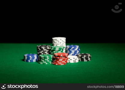 gambling, fortune, game and entertainment concept - close up of casino chips on green table surface