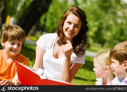 Game in park. Image of children with nurse playing in park