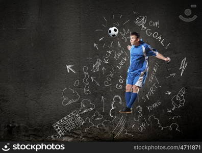 Game strategy. Football player in jump striking ball with sketches at backdrop