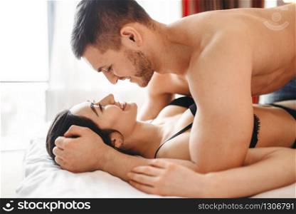 Games of intimate partners in bedroom, hot intimacy lovers. Passionate love couple, erotic in bed. Games of intimate partners in bedroom, hot lovers