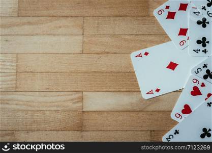 Gaming cards are lying on wood table. Playing cards at home, copy space.