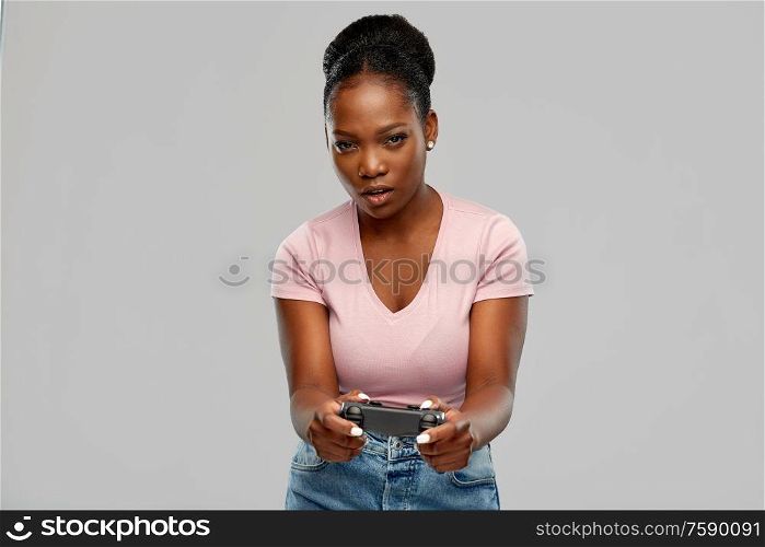 gaming, technology and people concept - african american woman with gamepad playig video game. african american woman with gamepad playig game