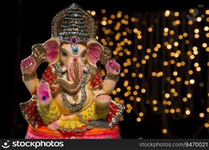 ganesh idol with lights in background