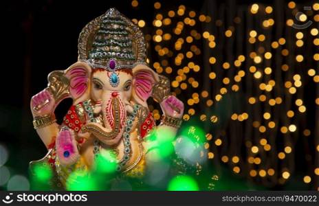 ganesh idol with lights in background