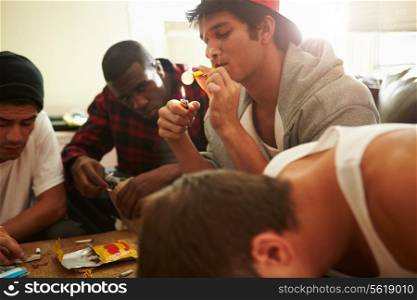 Gang Of Young Men Taking Drugs Indoors