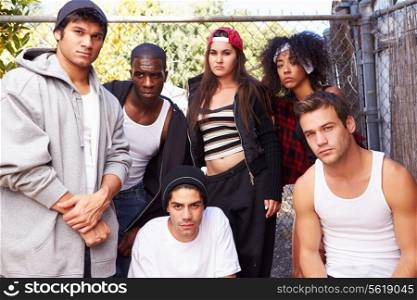 Gang Of Young People In Urban Setting Standing By Fence
