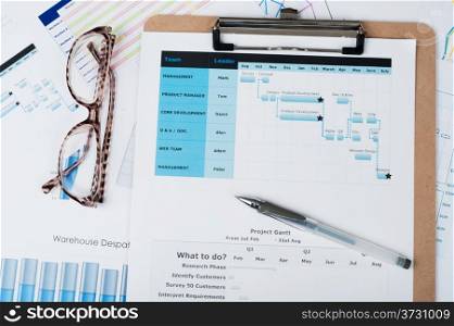 Gantt diagram printed on white paper with a pen on it
