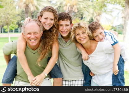 garandparents giving piggyback ride to their children