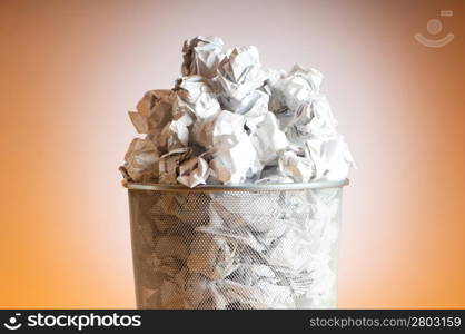 Garbage bin with paper waste isolated on white