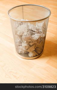 Garbage bin with paper waste isolated on white