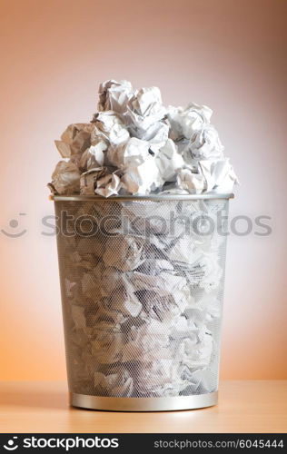 Garbage bin with paper waste isolated on white